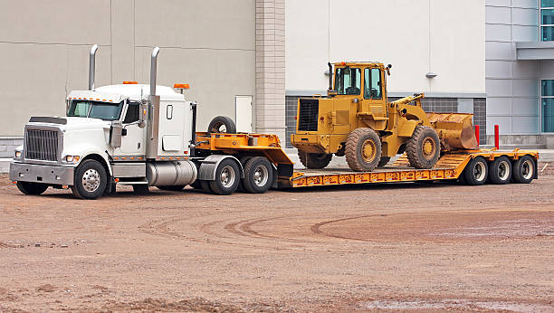 heavy duty equipment being transferred on back of truck bed