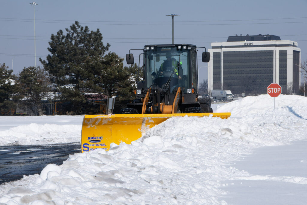 arctic snow and ice sectional snow plow plowing snow