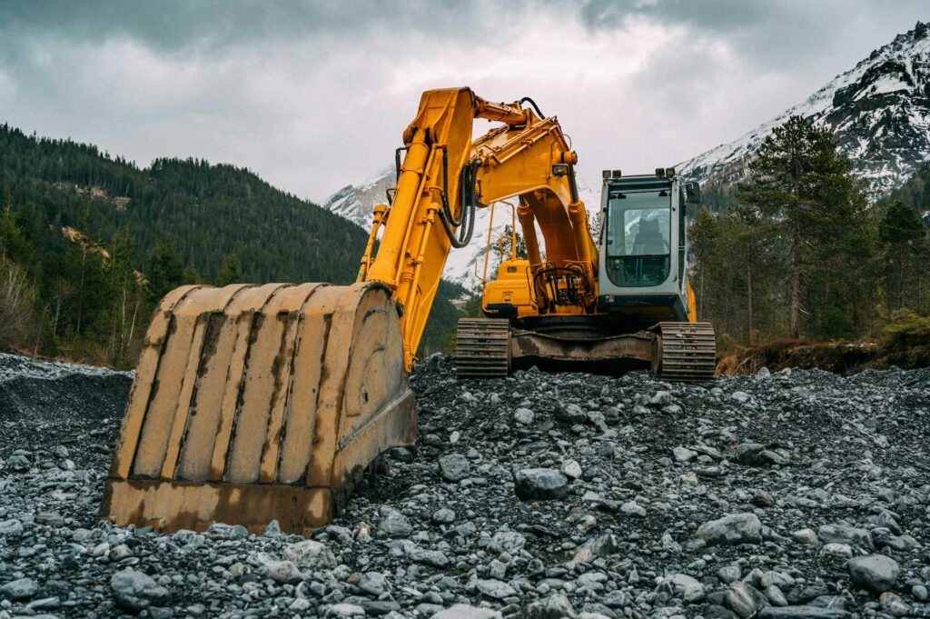 excavator-grabbing-stones-with-snowy-mountains-in-alberta