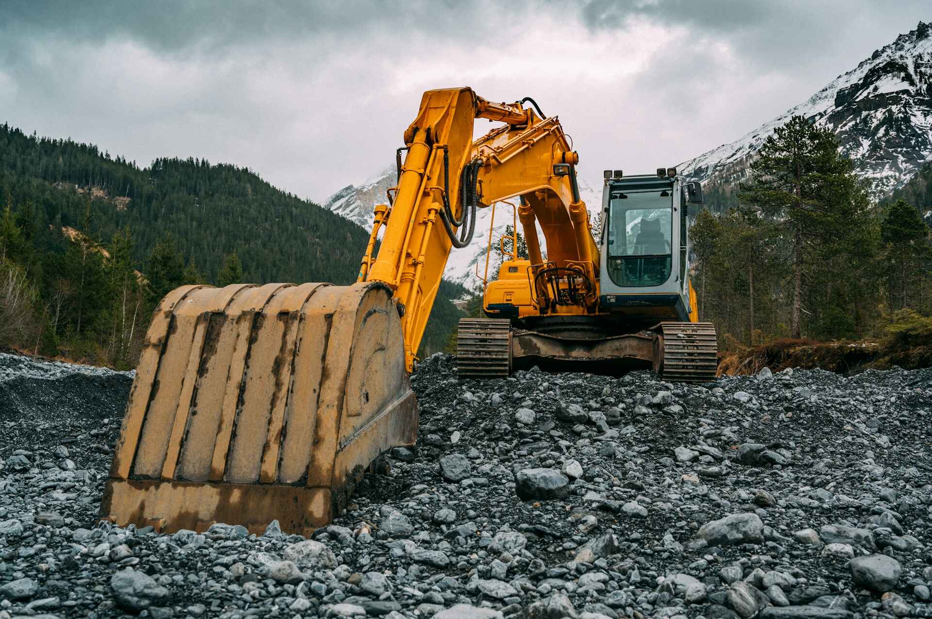 excavator-grabbing-stones-with-snowy-mountains-in-alberta