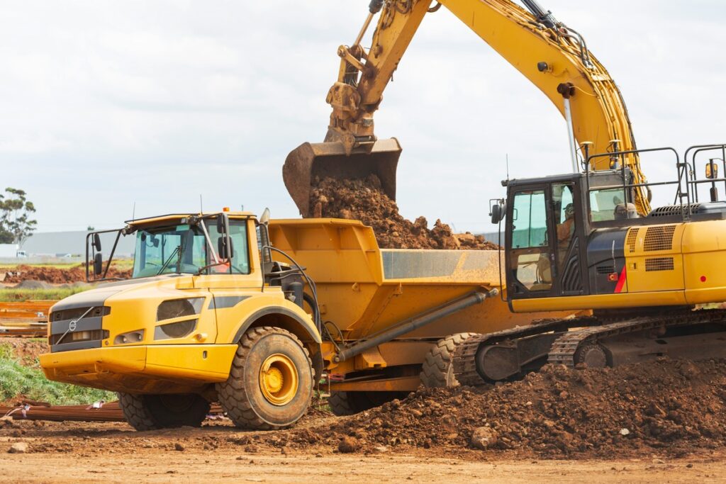 hyundai excavator putting dirt in truck bed best heavy duty equipment