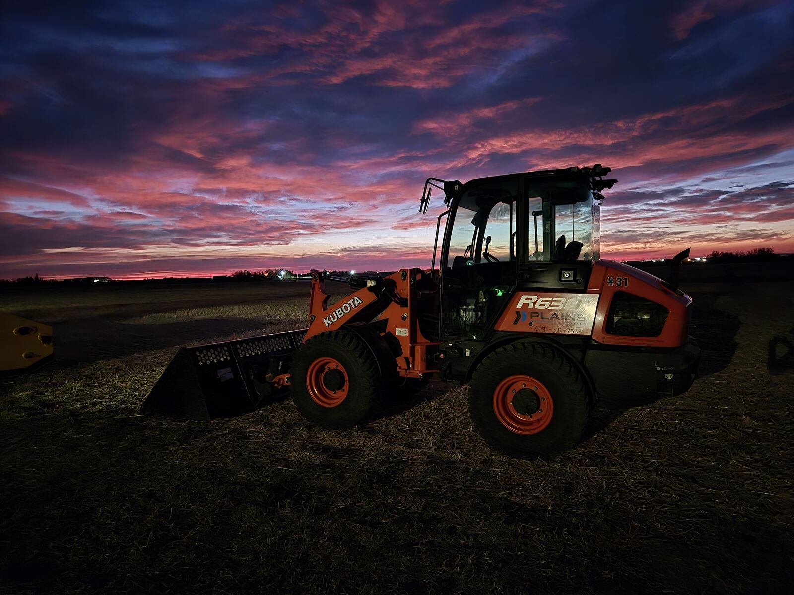 Kubota R630 loader at sunset, available for rent for construction and material handling across Western Canada