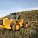 John Deere 524K-II wheel loader for sale, photographed in Western Canada field at sunset