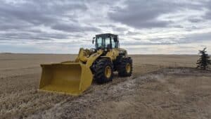 2010 Komatsu WA250-6 wheel loader with front bucket angled in Alberta